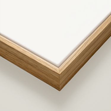 Close-up of a square framed print or canvas corner, showing a light natural wood frame with a white mat or artwork surface on a light neutral background.