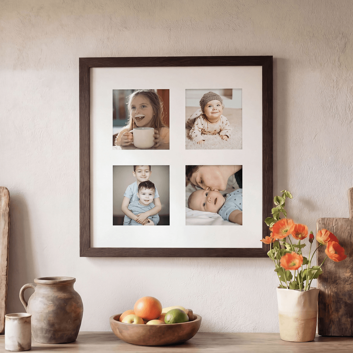 Framed photo collage of children on a wall above a table with fruit and flowers.