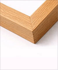 Close-up of a light oak wood picture frame corner on a white background.